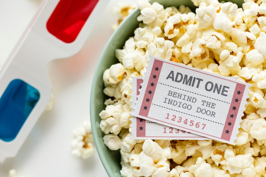 Popcorn Bowl with movie tickets laying on popcorn and at the side of the bowl are 3D glasses