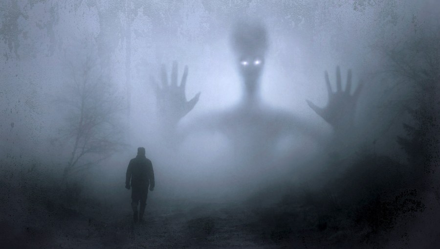 Man walking into fog with shadowy figure looking back at him
